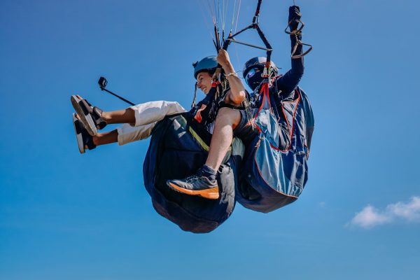 woman with instructor flying on parachute against sky 1